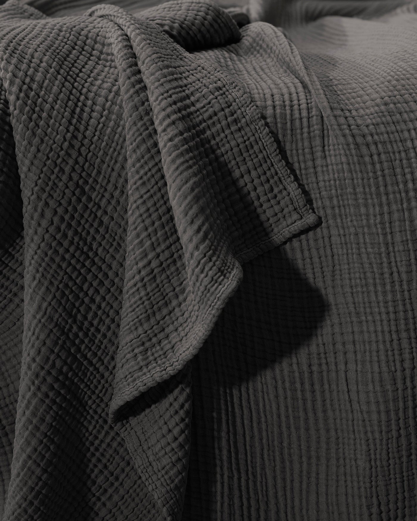 Close-up of Society Limonta Free New bedcover in charcoal, showing textured cotton gauze weave.