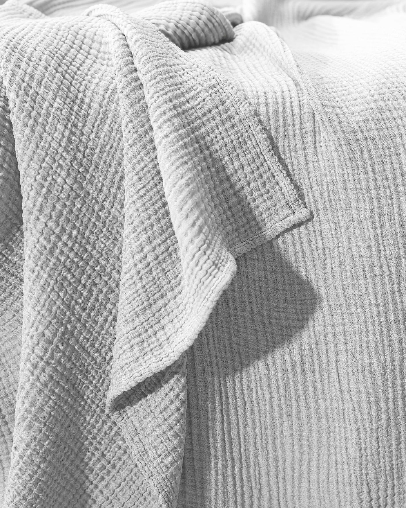 Close-up of Society Limonta Free New bedcover corner hem in dove grey crinkled cotton.
