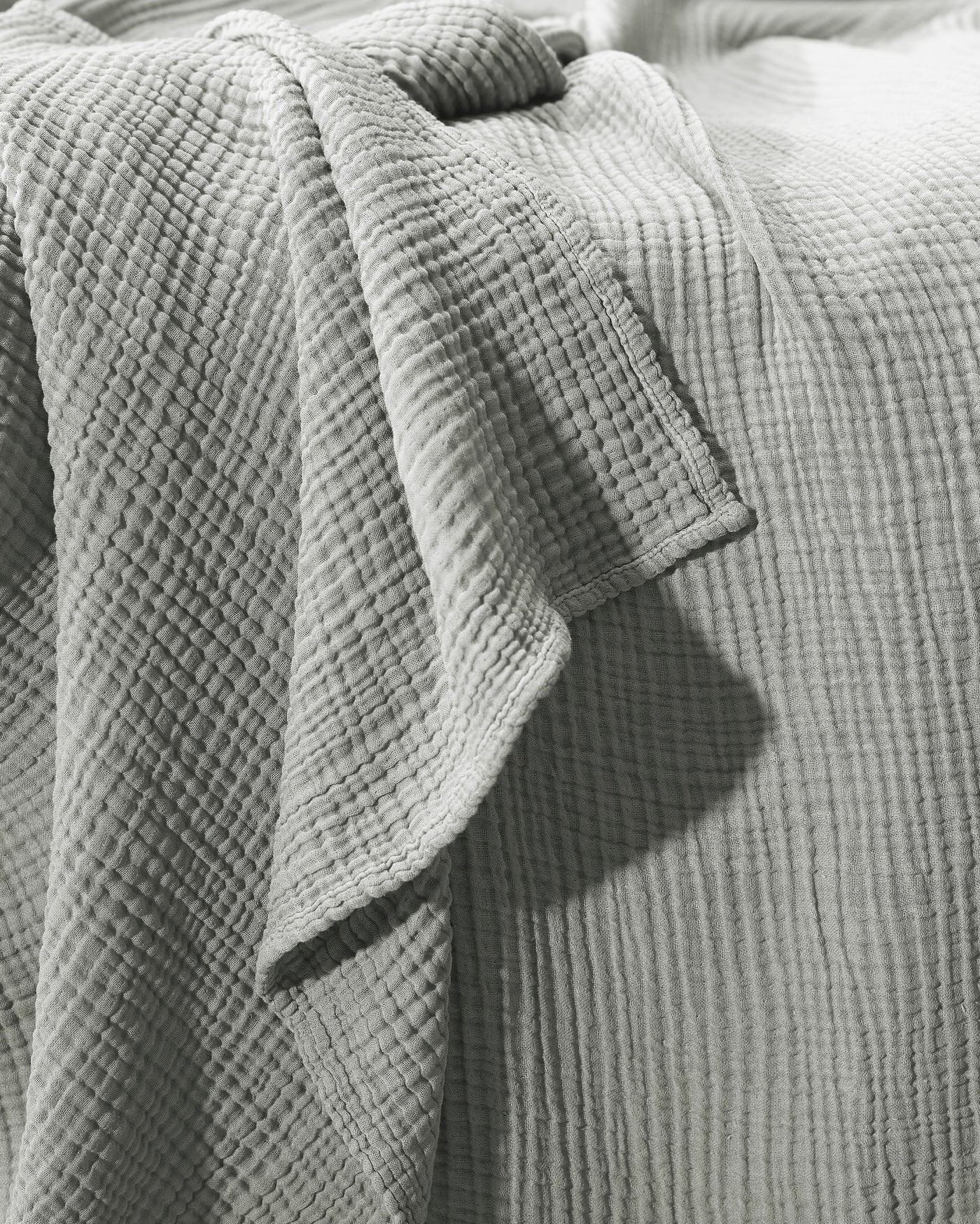 Close-up of Society Limonta Free New bedcover hem in sage, showing textured cotton weave.
