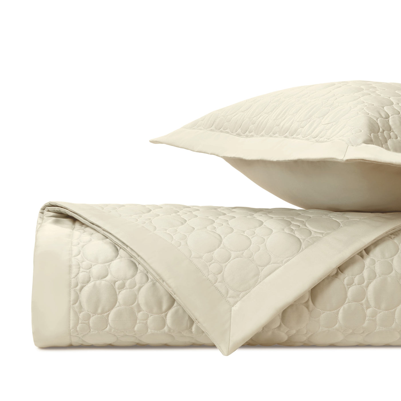Close-up of Home Treasures Globe quilted texture in ivory with circular stitching pattern.