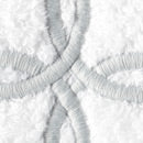 Close-up of white-on-white embroidered Gordian knot motif on textured cotton.