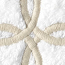 Close-up of embroidered ivory Gordian knot motif on white cotton terry.