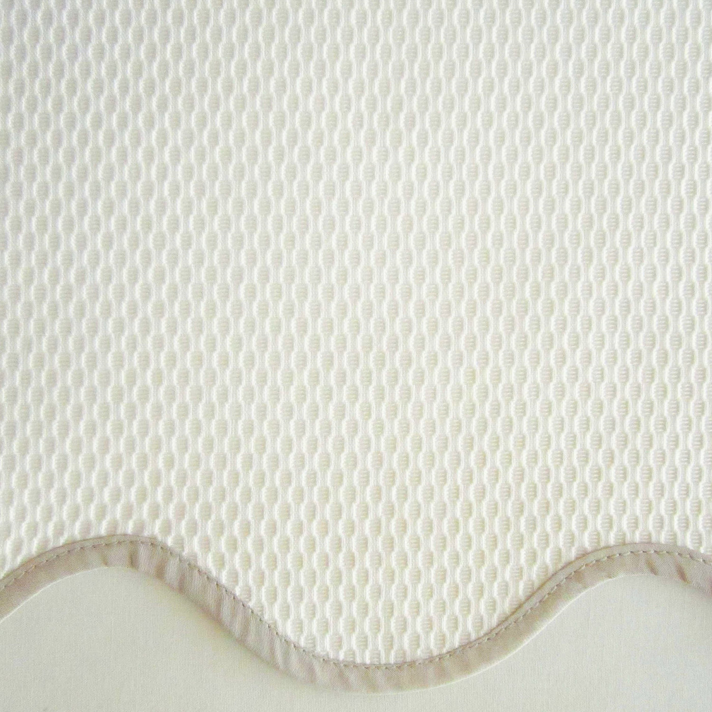Close-up of ivory Home Treasures Honeycomb fabric with scalloped edge detail.