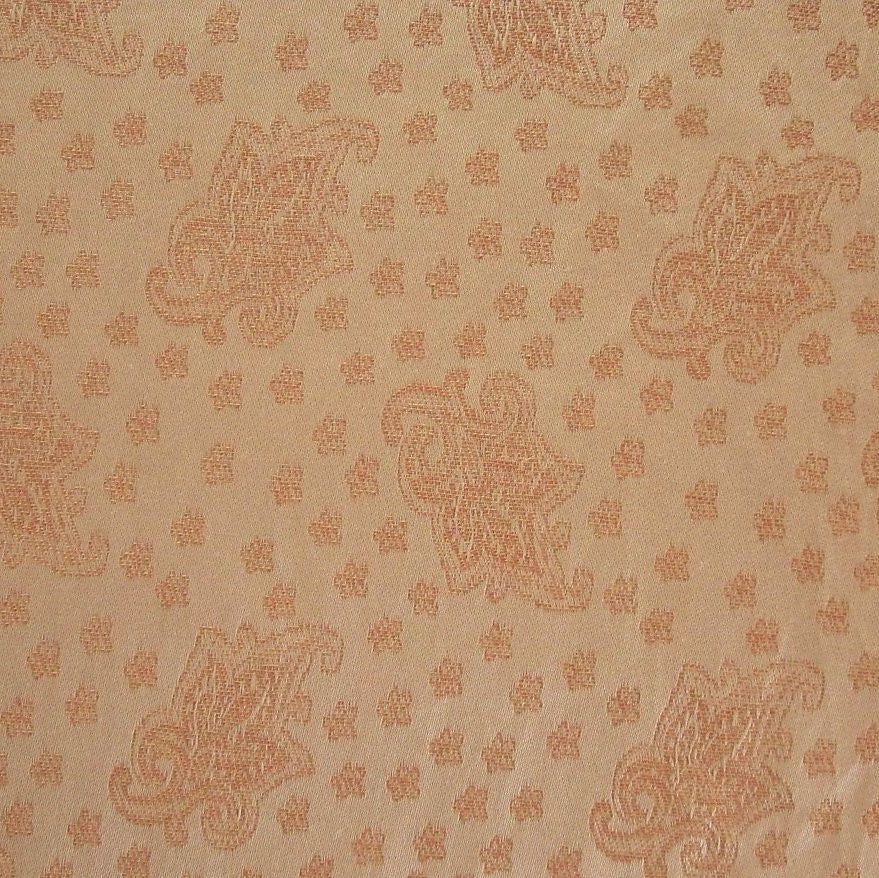 Close-up of champagne cotton fabric with tonal copper paisley and dot jacquard weave pattern.