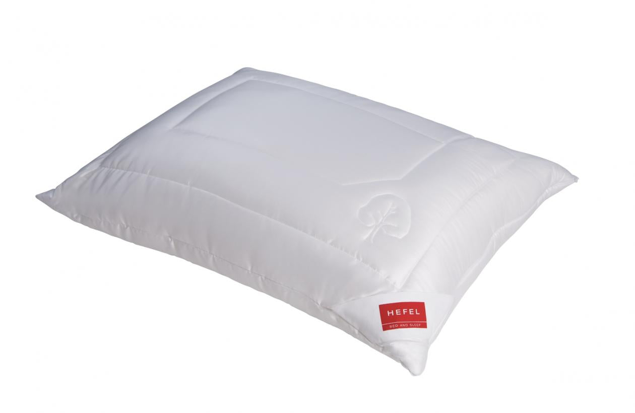 The Hefel Klima Control Comfort Pillow is a white rectangular pillow with a subtle stitched pattern and a red Hefel label, crafted from Tencel bedding for excellent moisture regulation.