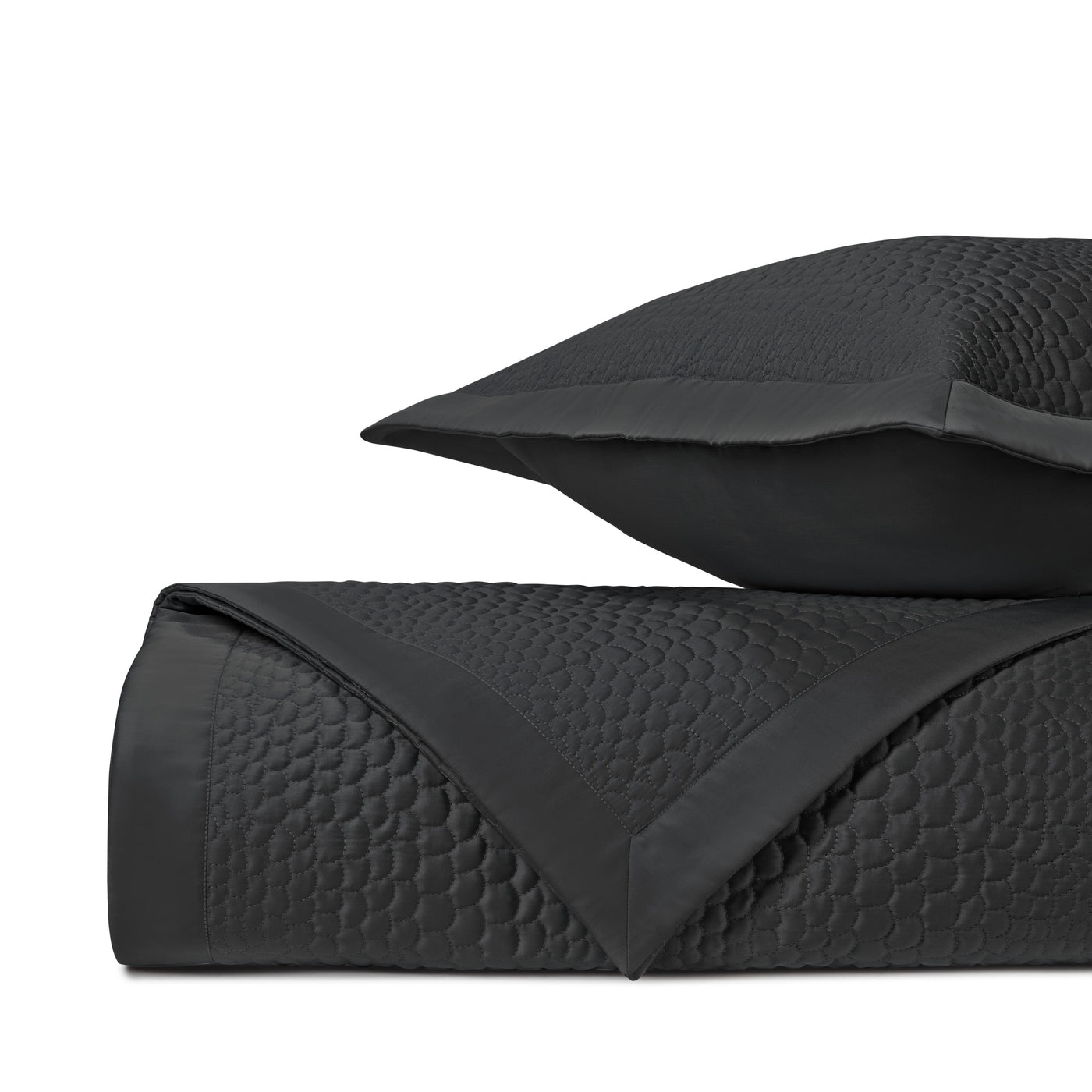 Close-up of Home Treasures Komodo quilted texture in black with geometric stitching.