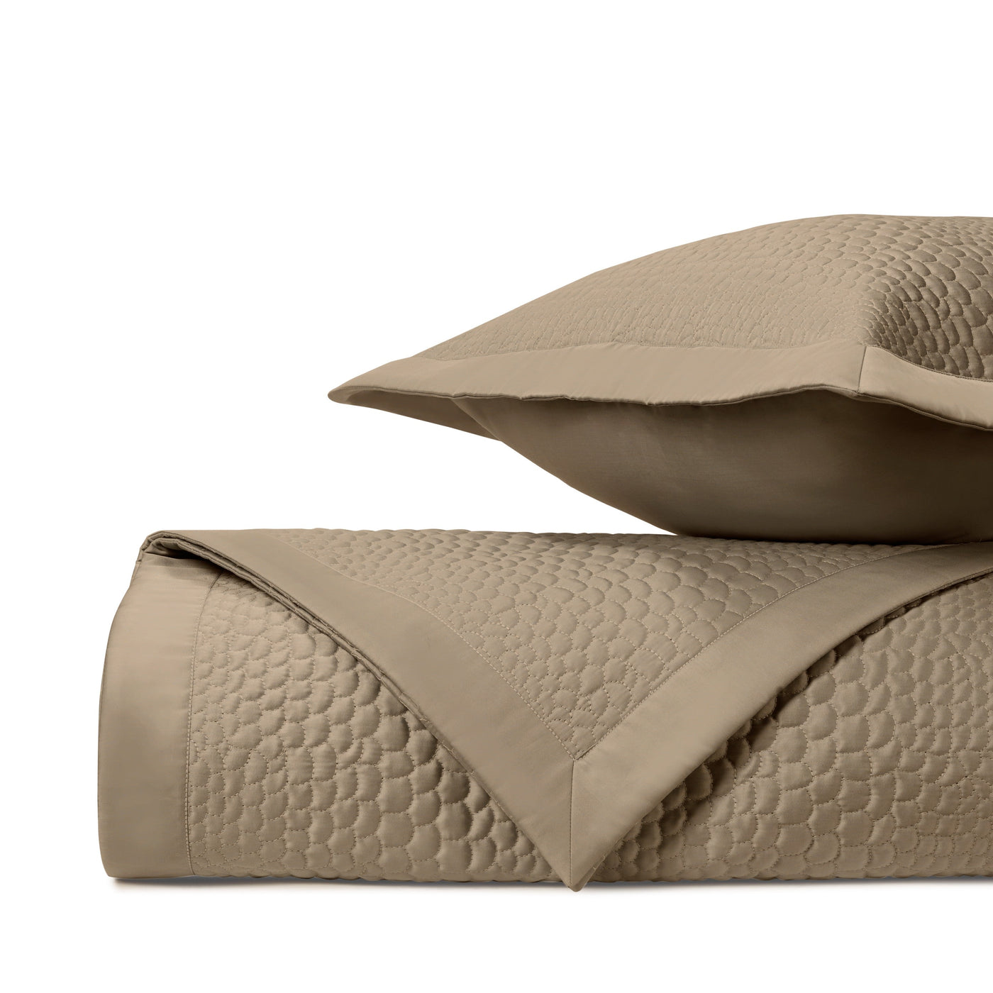 Close-up of Komodo quilted texture in taupe with geometric honeycomb stitching pattern.