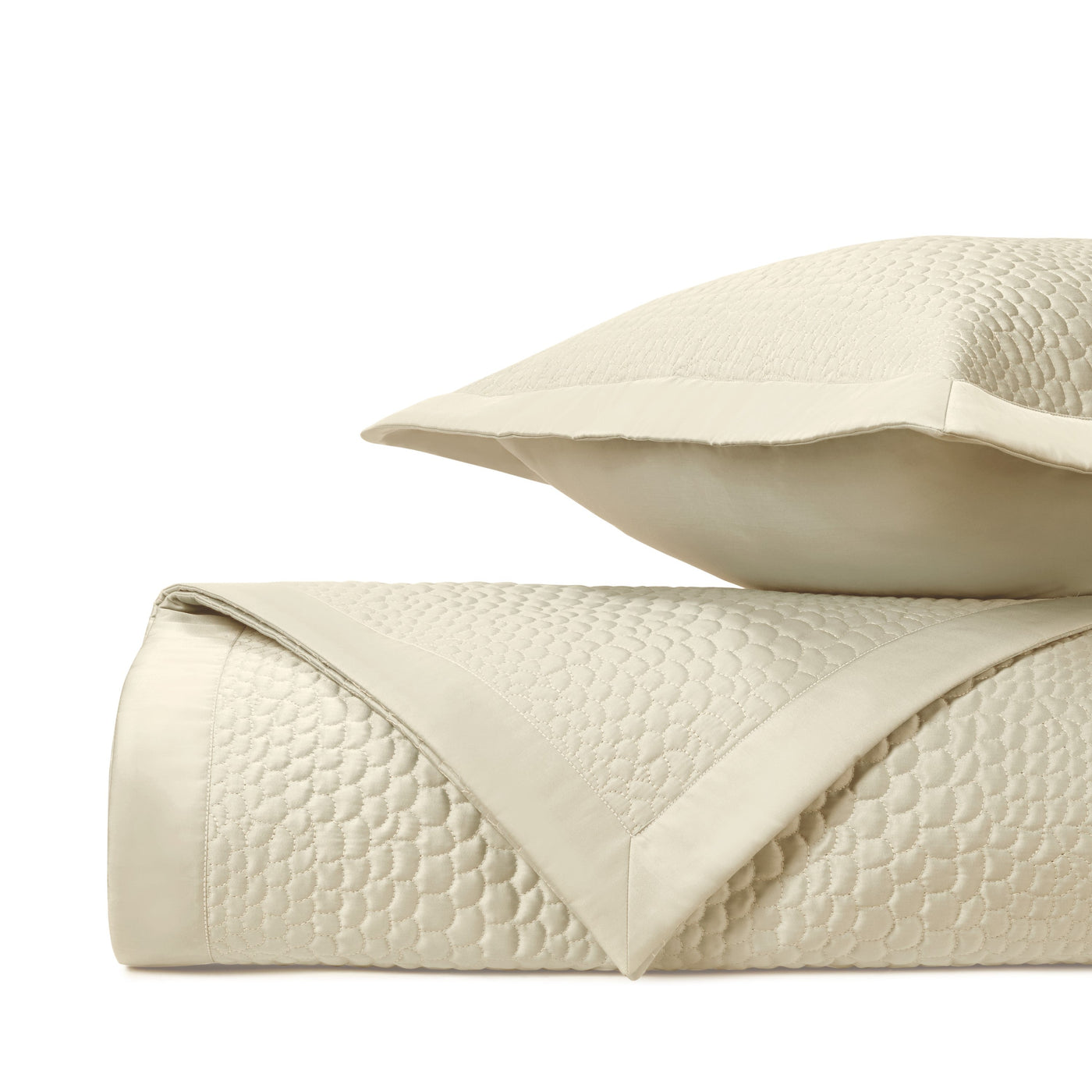 Home Treasures Komodo ivory quilted coverlet and sham folded stack.