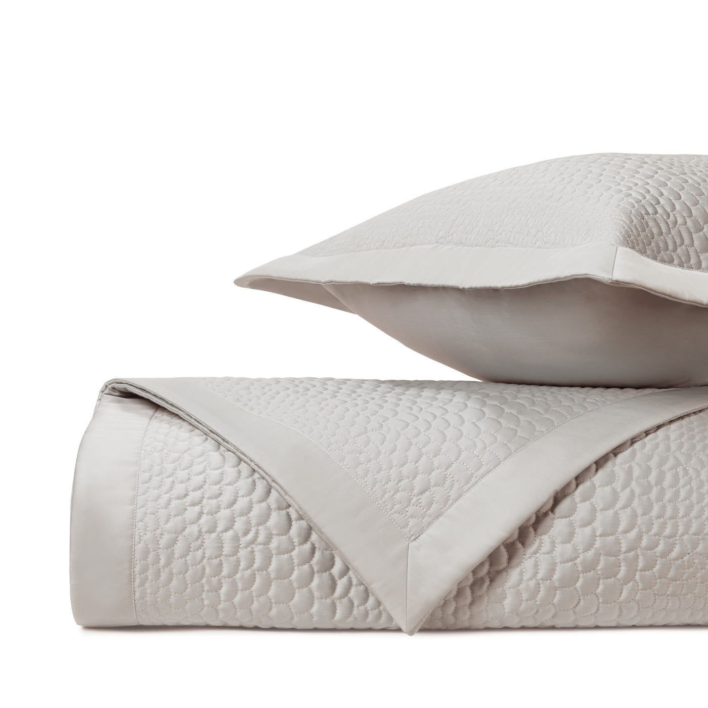 Close-up of Home Treasures Komodo quilted texture in pearl with satin border detail.
