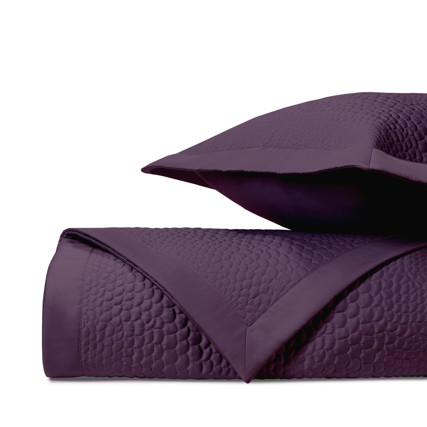 Close-up of Home Treasures Komodo quilted coverlet in deep plum with geometric stitching.