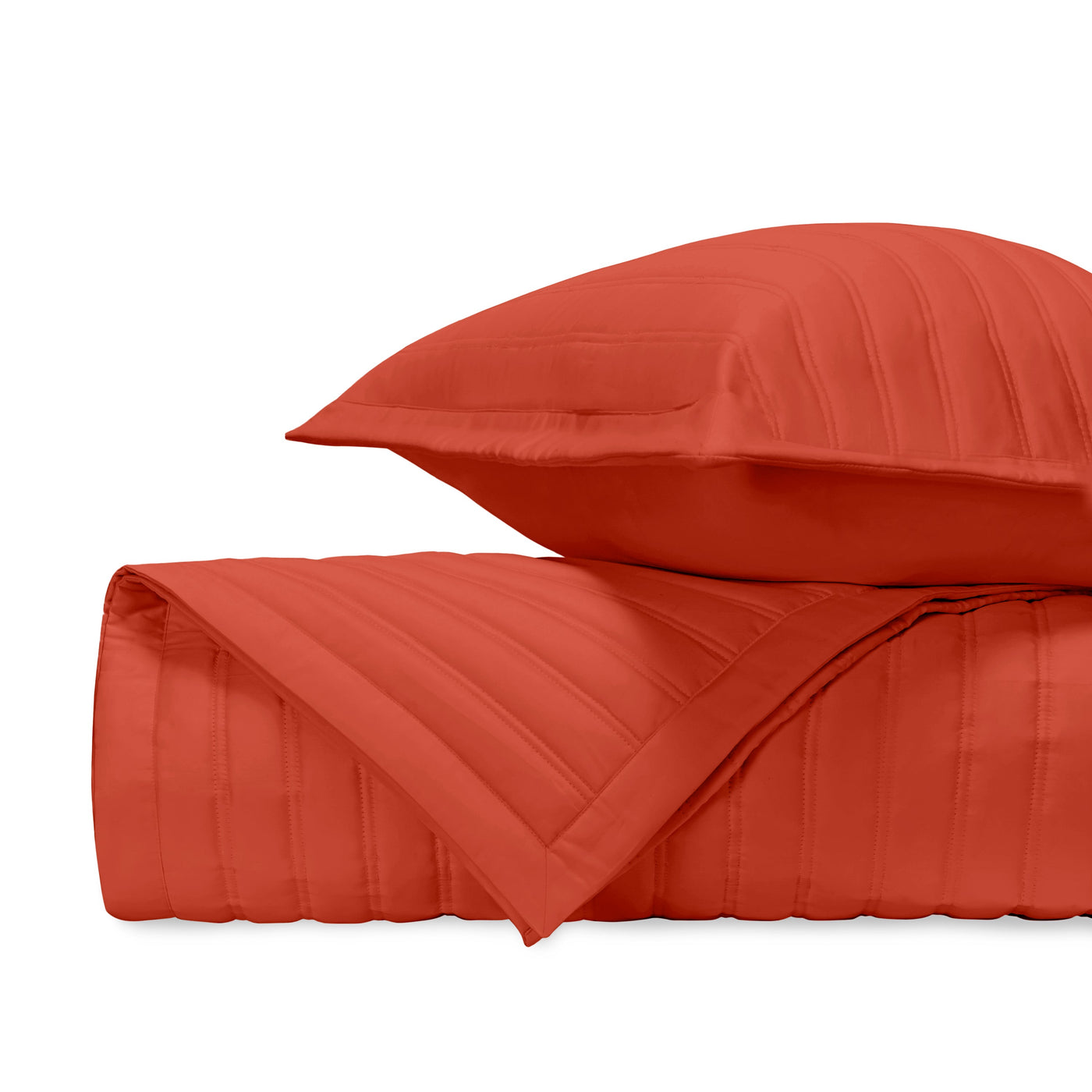 Close-up of L'Avenue quilted bedding in tomato red with parallel channel stitching.