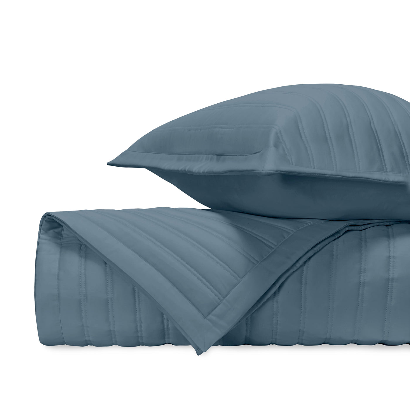 Close-up of L'Avenue quilted coverlet and sham in slate blue with parallel channel stitching.