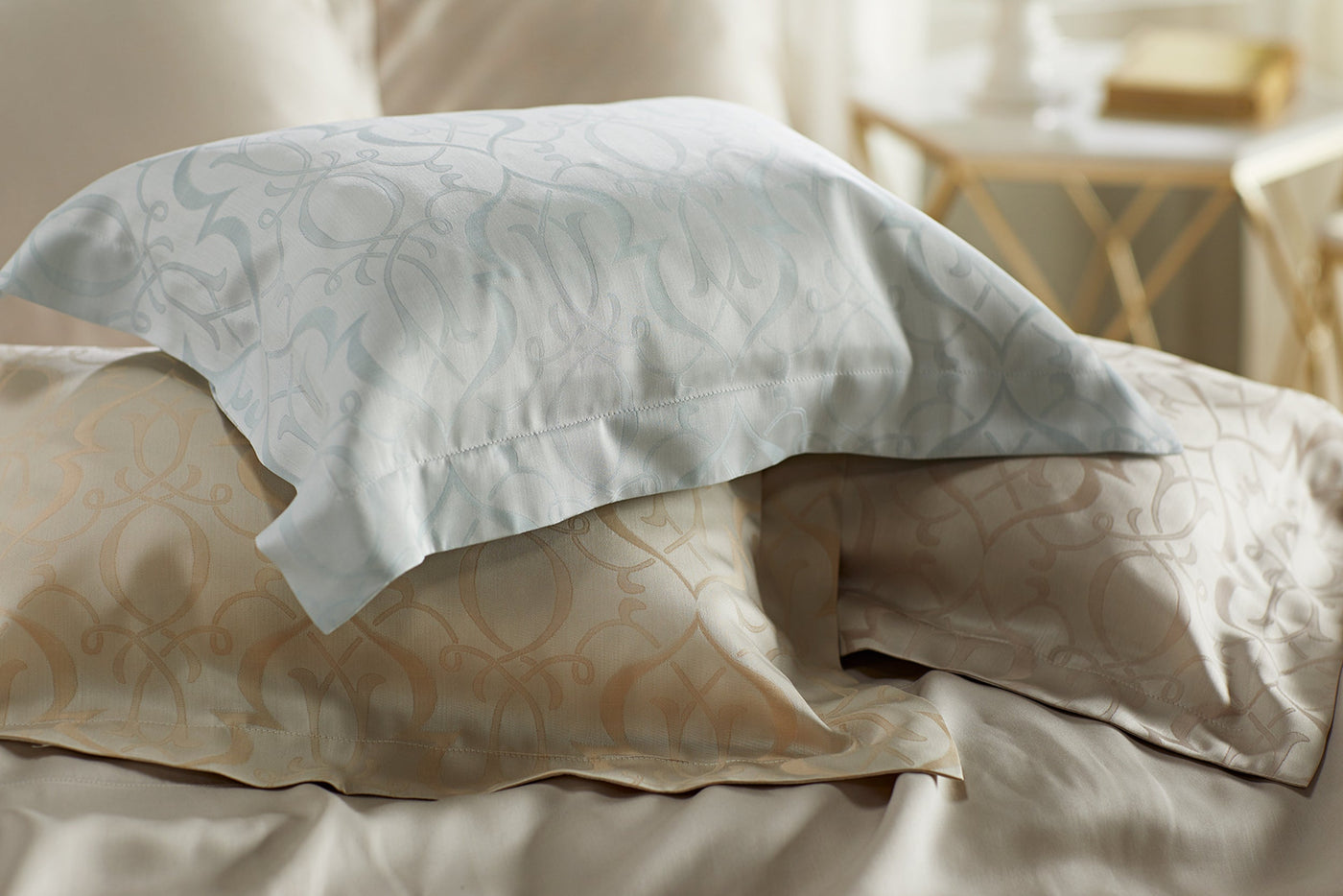 Legna Agadir bed skirt in champagne, styled on a made bed with jacquard pillowcases.