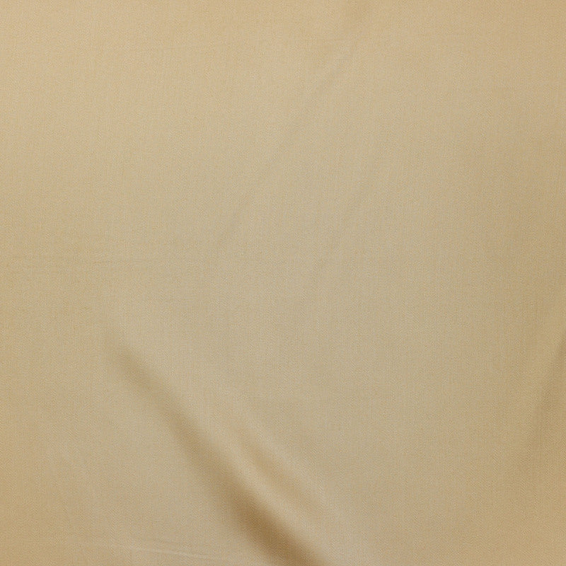 Close-up of draped champagne linen fabric showing subtle weave texture and soft folds.