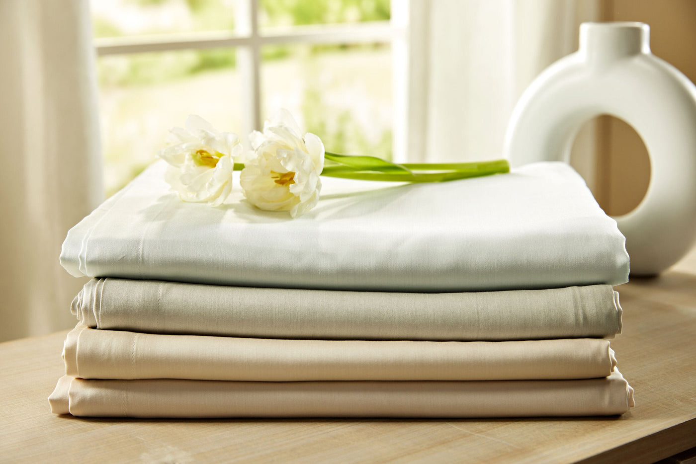 Legna Dahlia yardage folded in ivory, sage, and champagne tones, styled with white tulips.