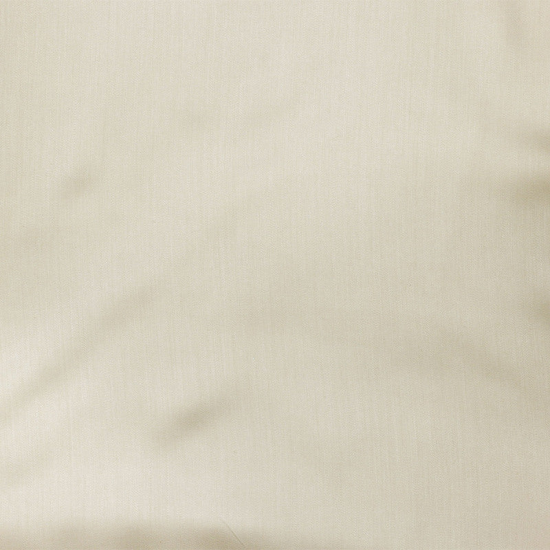 Close-up of ivory Legna Dahlia fabric yardage showing subtle woven texture and soft drape.