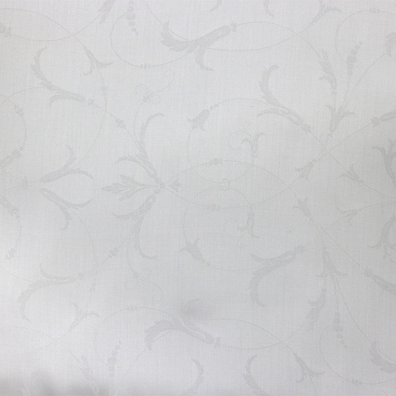 Close-up of Legna Seville pillow fabric showing tonal white jacquard scroll pattern.