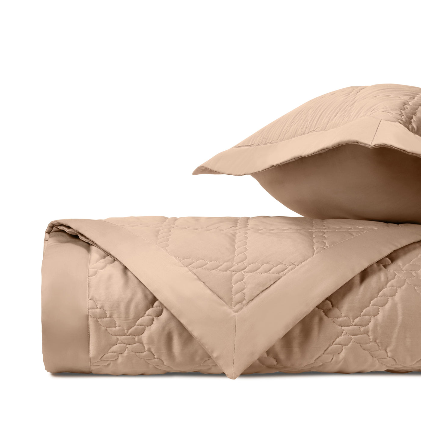 Close-up of Liberty quilted camel coverlet folded beside a matching sham.