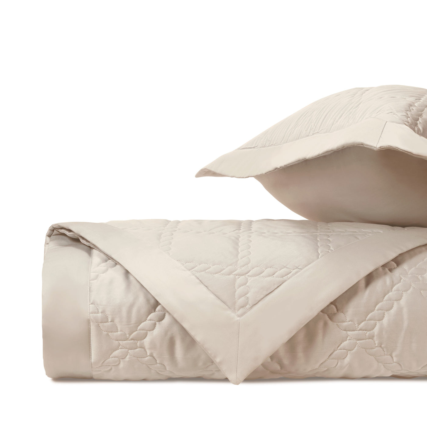 Ivory quilted texture close-up showing diamond stitching pattern and satin border detail.