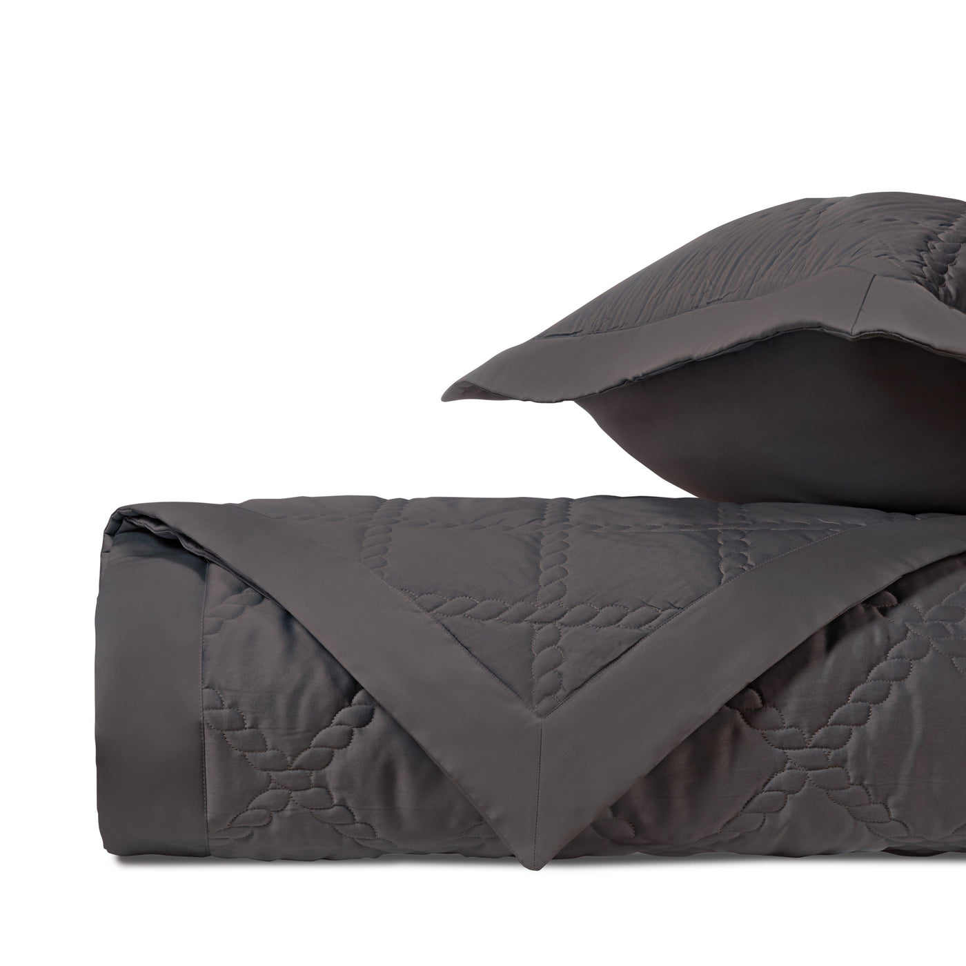 Close-up of charcoal quilted fabric with geometric diamond stitching pattern.