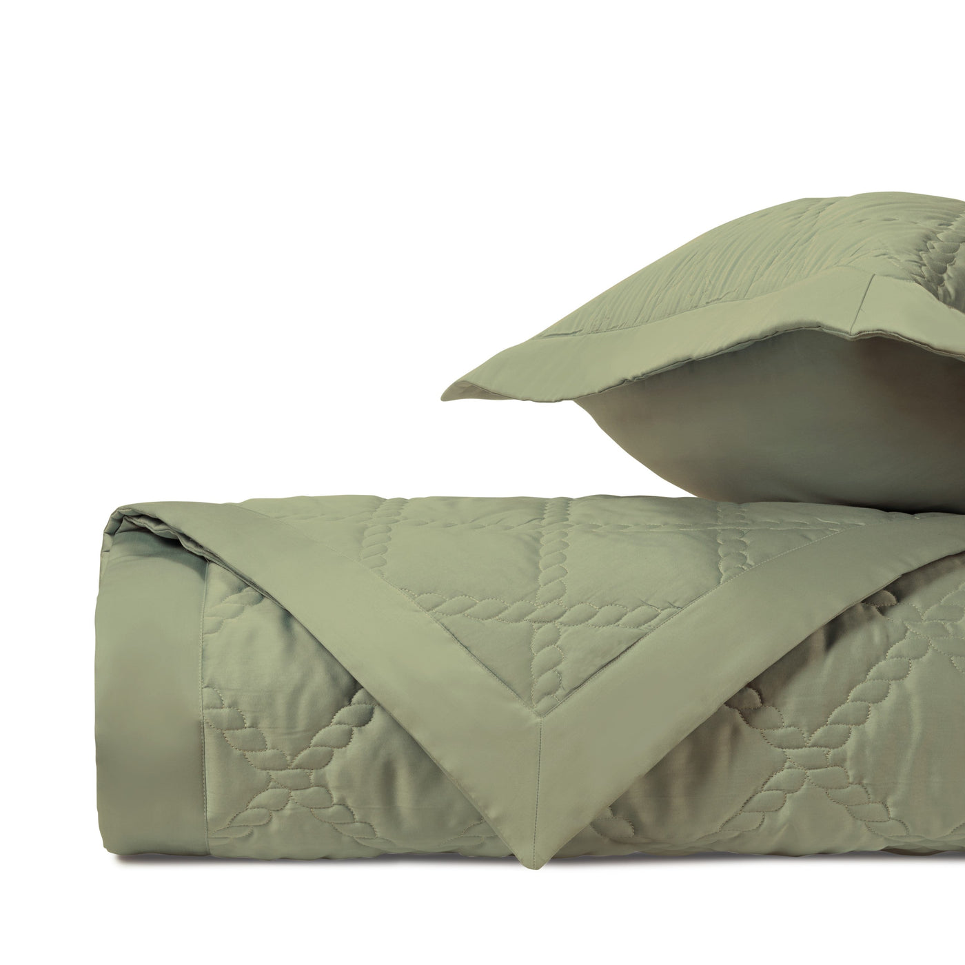 Close-up of sage green quilted satin with geometric diamond stitching pattern.