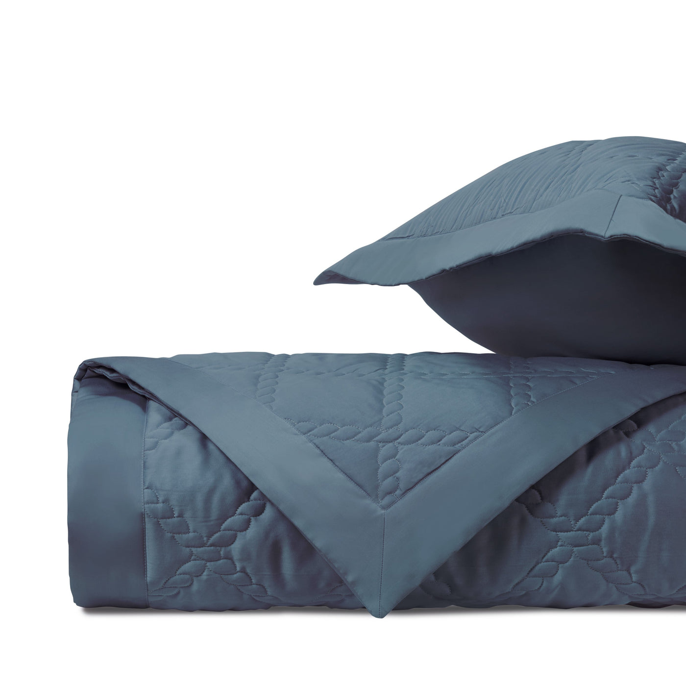 Close-up of slate blue quilted cotton with diamond and rope stitch pattern detail.