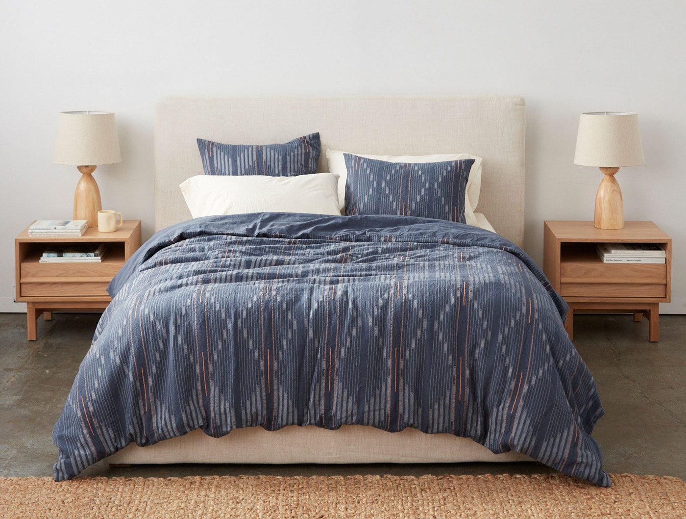 Coyuchi Morelia duvet cover in slate blue ikat pattern styled on a made bed.