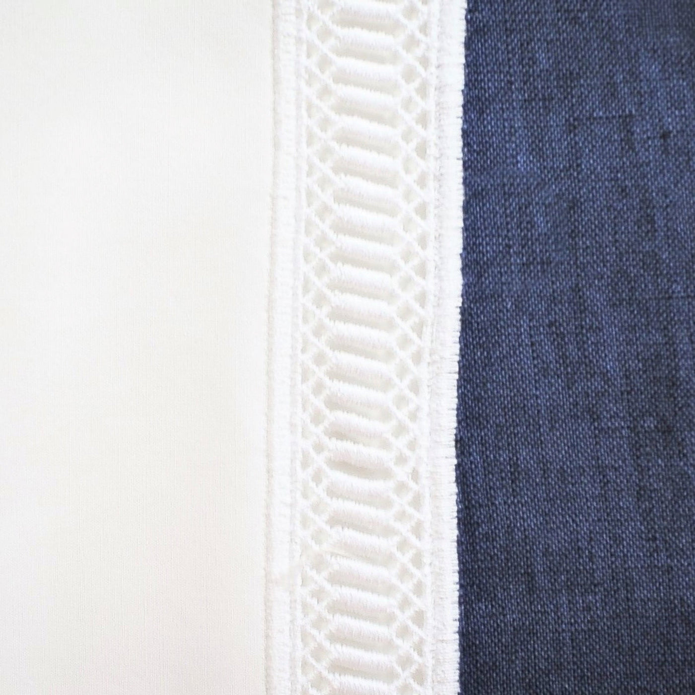 Close-up of ivory and navy linen with white ladder lace trim detail.