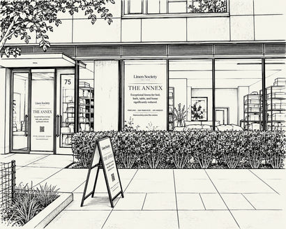 Black and white architectural illustration of a storefront building with large windows, signage reading 'Linen Society' and 'THE ANNEX,' a sidewalk, shrubs, and a freestanding A-frame sign.