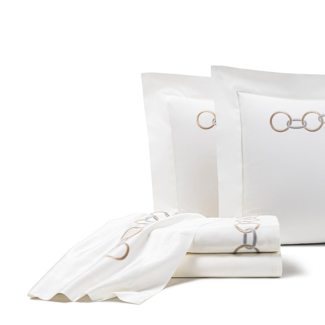 Frette Links Embroidered Sheet Set: white cotton sateen bedding with two pillows, a folded sheet, and a towel, all featuring beige and gray interlocking ring embroidery.
