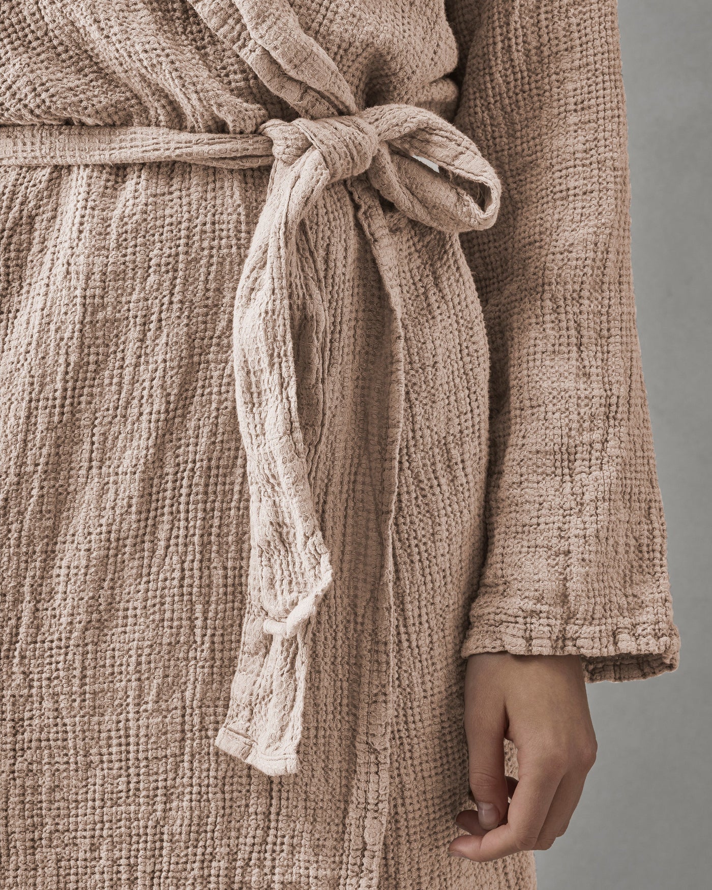 Close-up of knotted waist tie on Society Limonta Lipe New robe in blush textured cotton gauze.