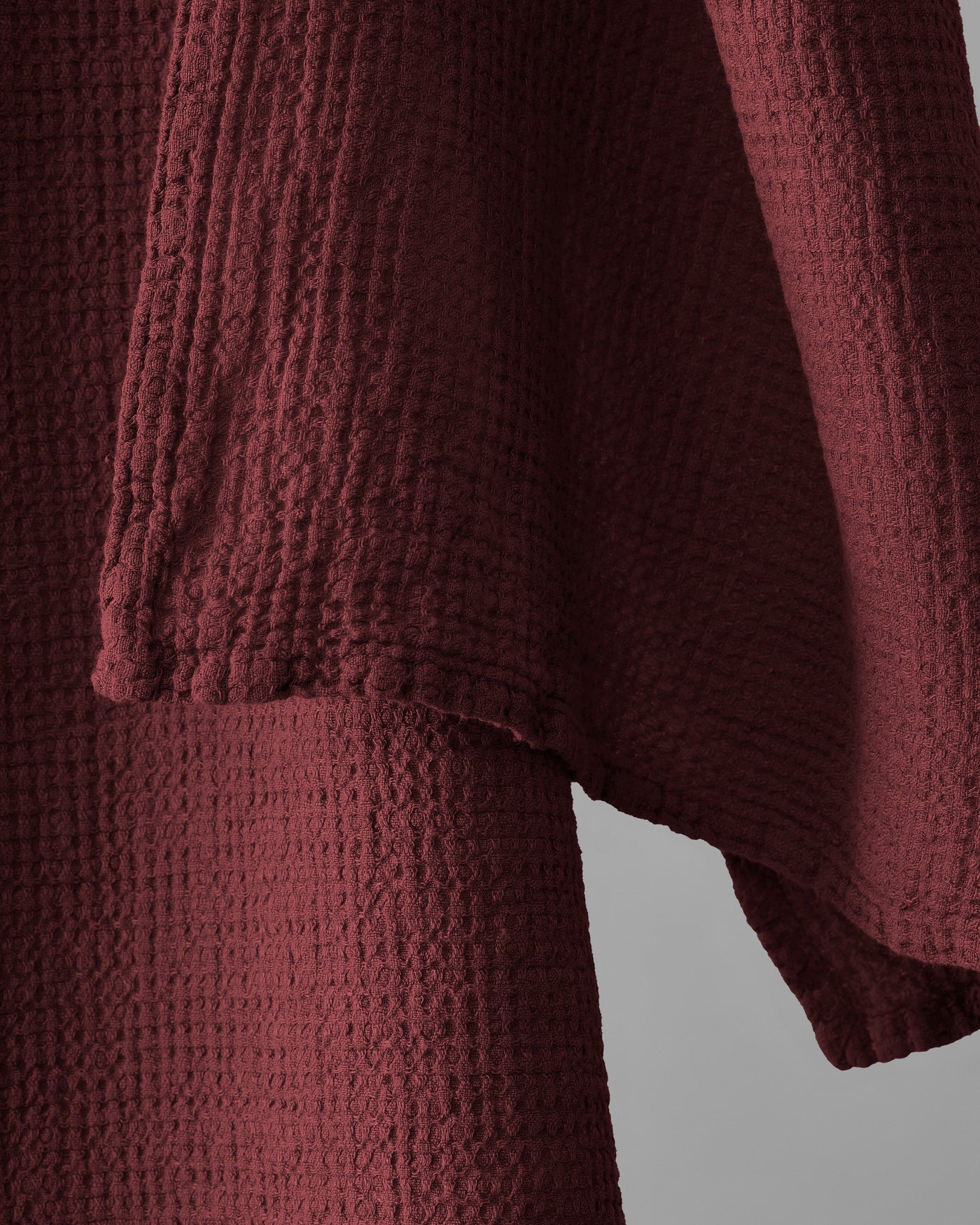 Close-up of crimson waffle-weave cotton texture and side pocket detail.