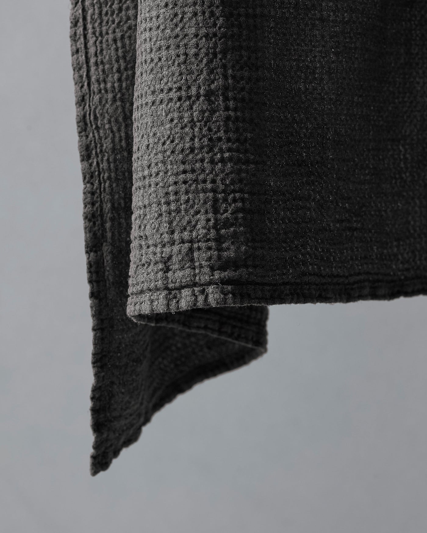 Close-up of charcoal waffle-weave texture and folded edge of Society Limonta Lipe New towel.