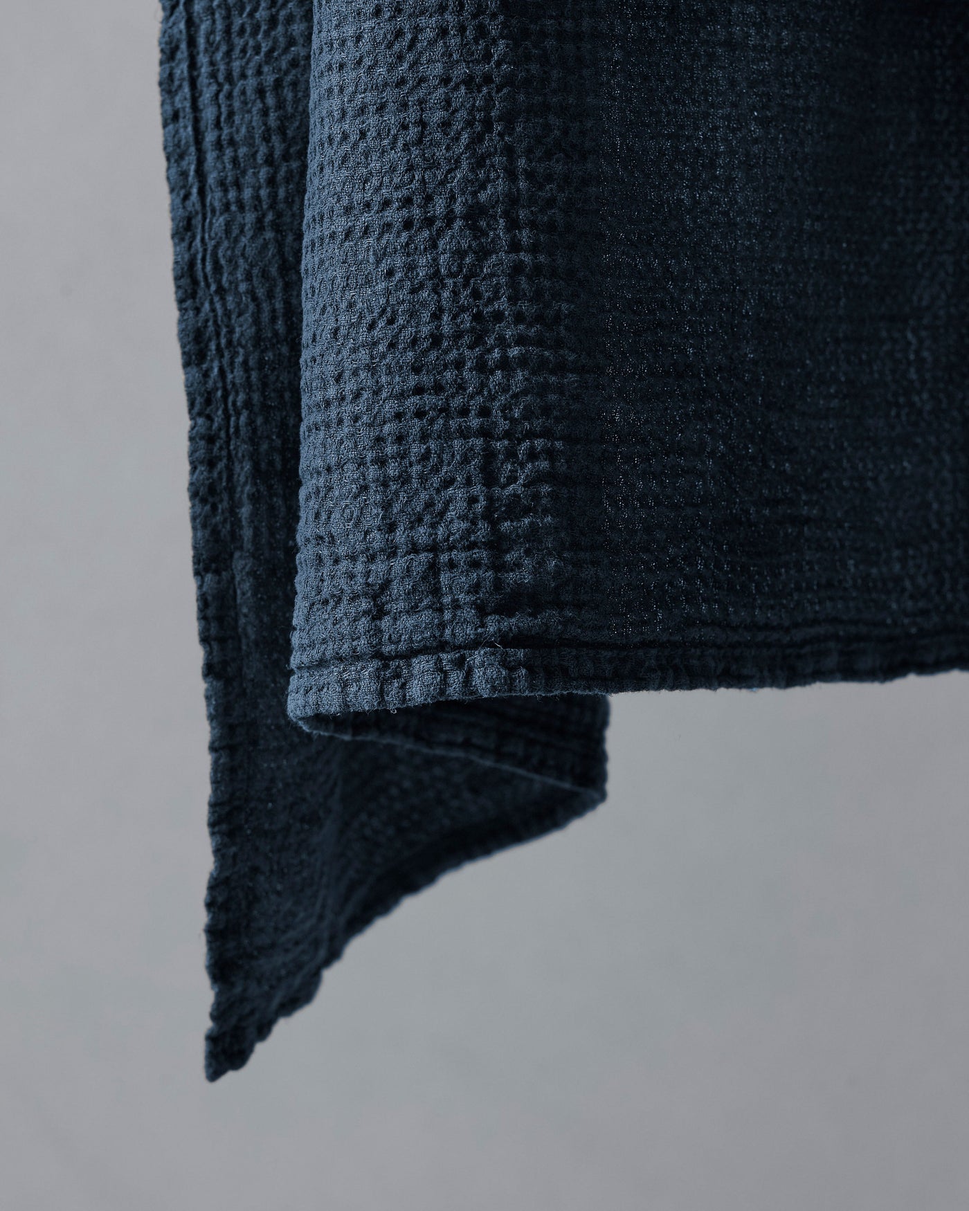 Close-up of Society Limonta Lipe New hand towel corner in midnight blue waffle-weave linen.