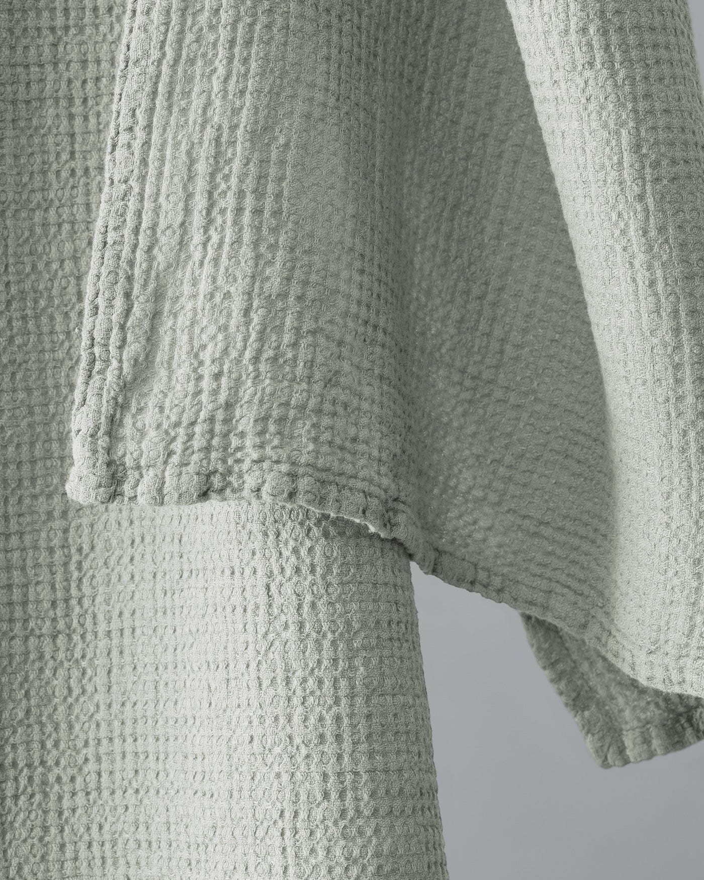 Close-up of sage waffle-weave texture and stitched hem detail on Society Limonta Lipe New hand towel.