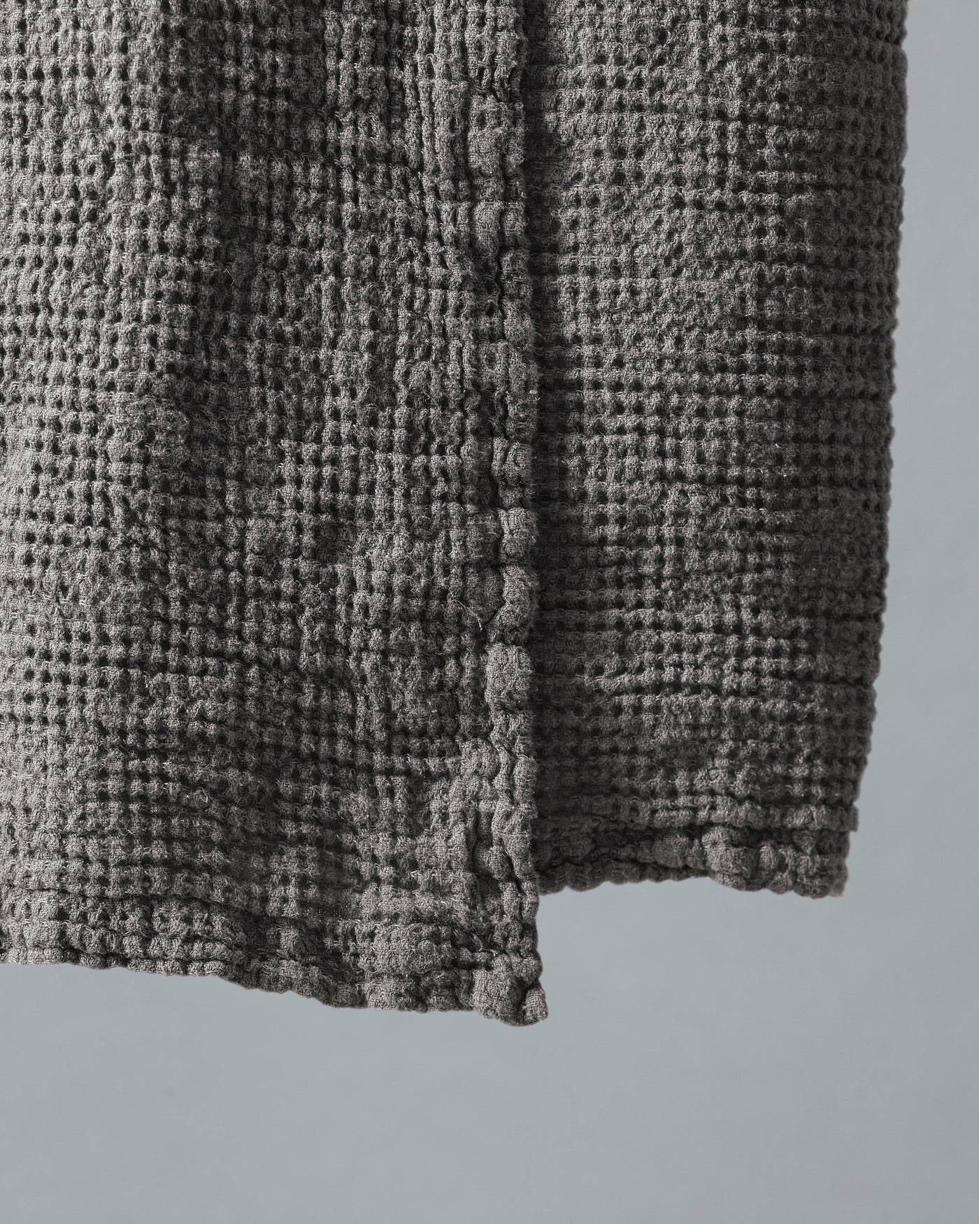Close-up of charcoal waffle-weave texture and hemmed edge of Society Limonta Lipe New bath towel.