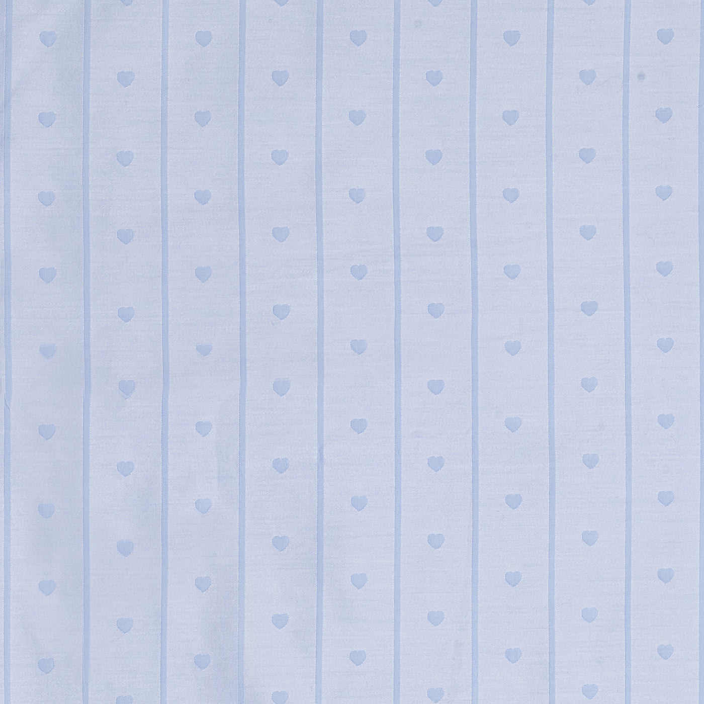Close-up of cornflower blue cotton fabric with woven stripe and heart motif pattern.