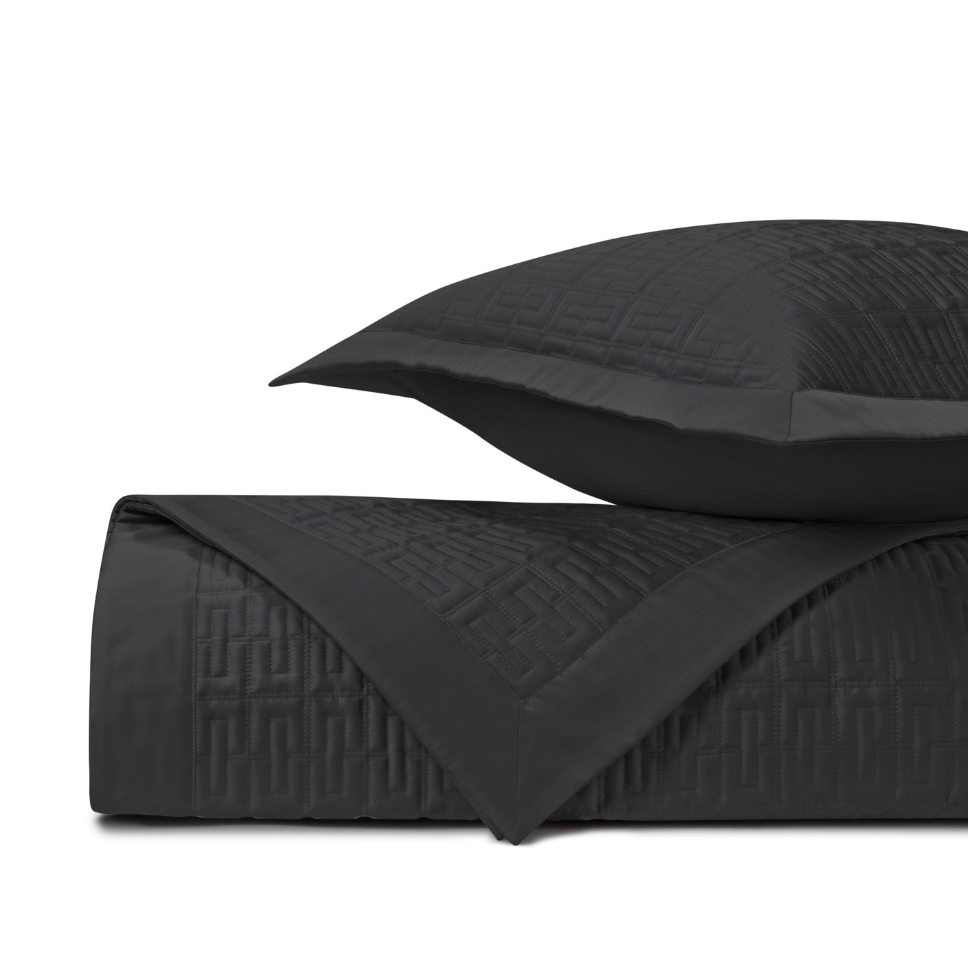 Close-up of Londres quilted coverlet in black with geometric Greek key stitching pattern.