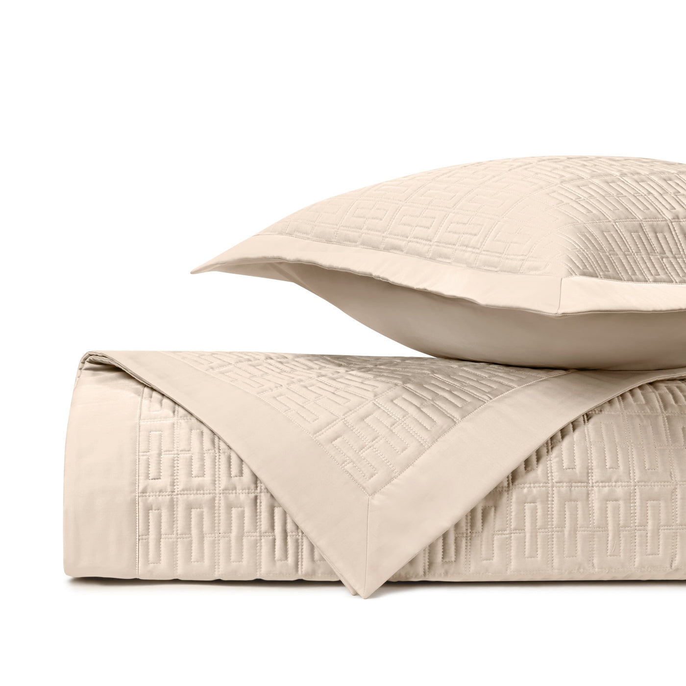 Close-up of ivory quilted satin with geometric Greek key pattern and contrast border.