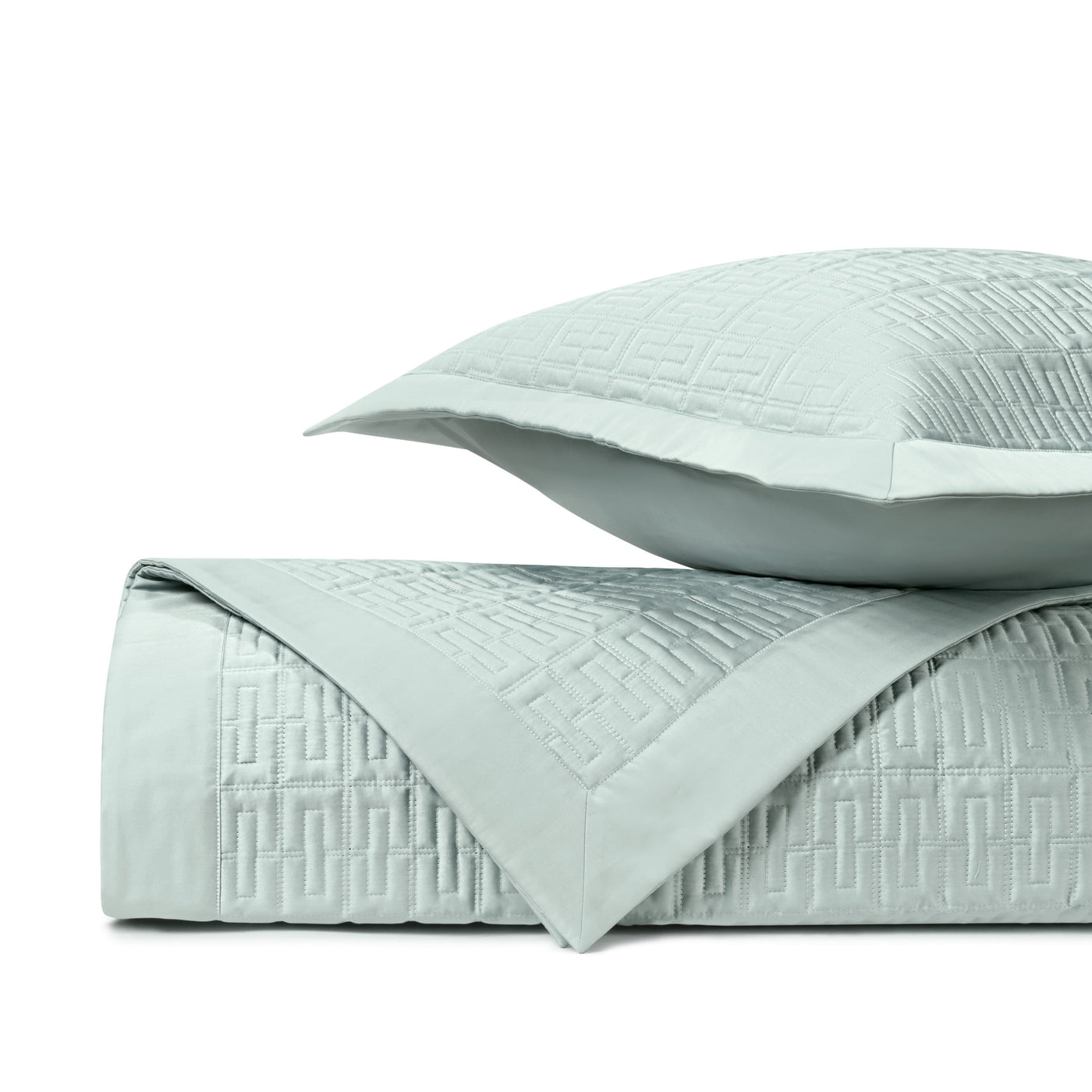 Close-up of mist blue quilted coverlet with geometric Greek key border pattern and matching sham.
