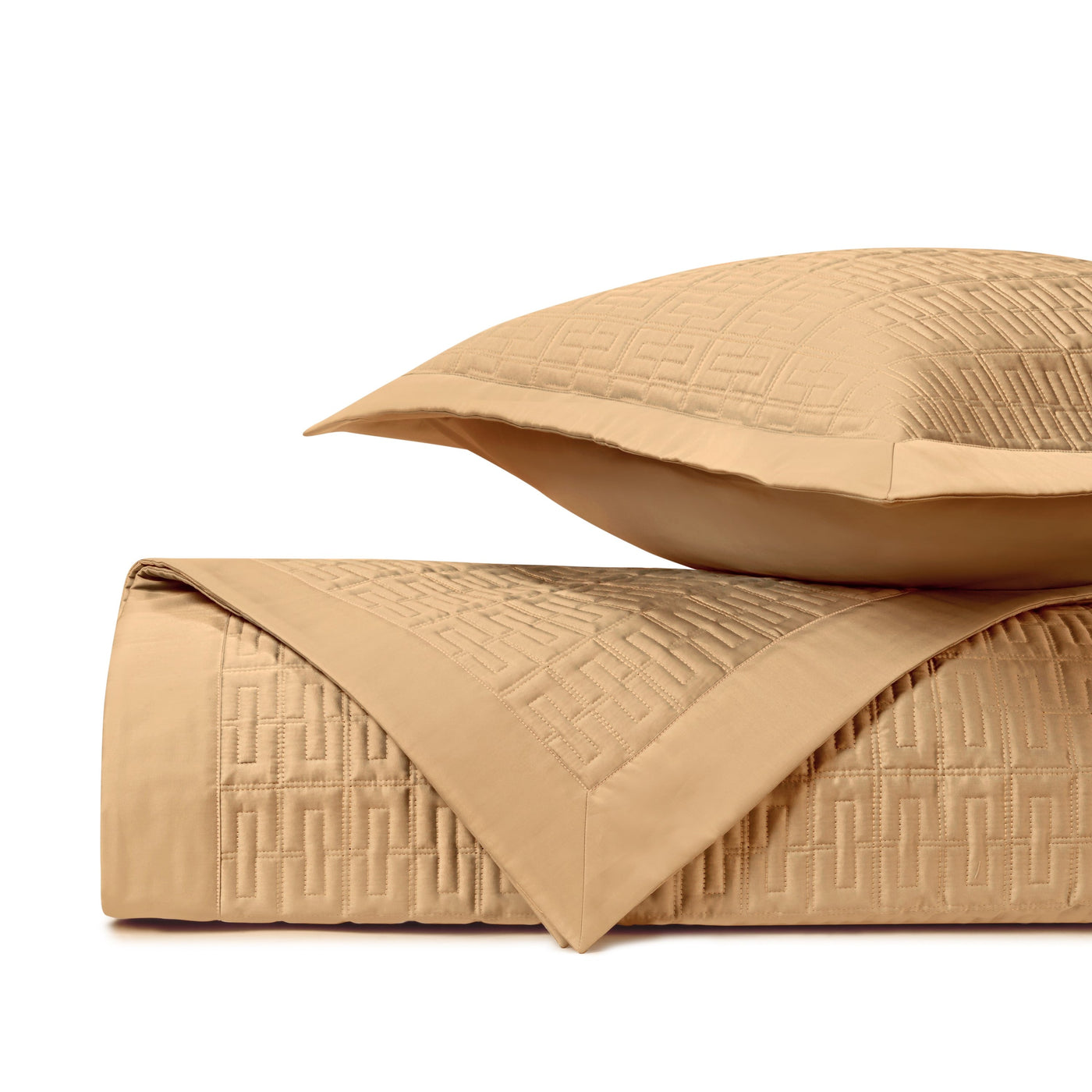 Honey quilted coverlet folded with matching sham, showing geometric Greek key stitching detail.