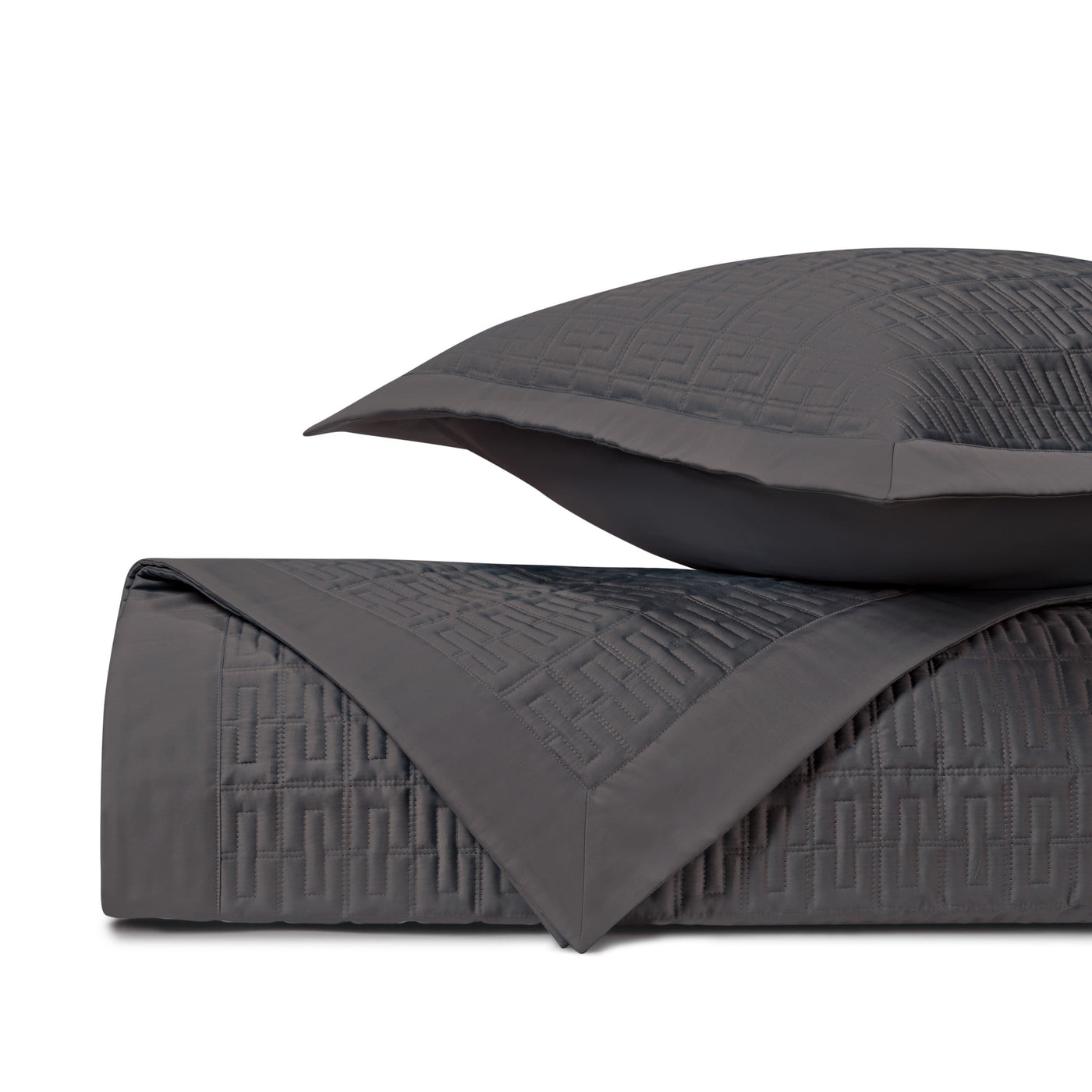 Close-up of Londres quilted coverlet in charcoal with geometric basket-weave stitching pattern.