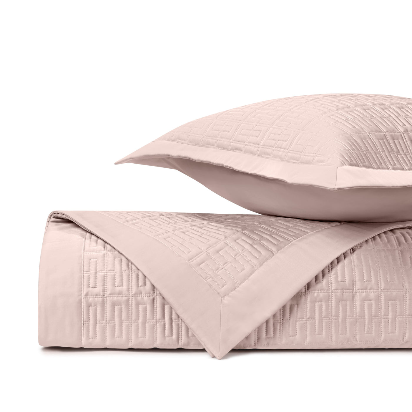 Close-up of Londres quilted coverlet in blush with geometric Greek key stitching pattern.
