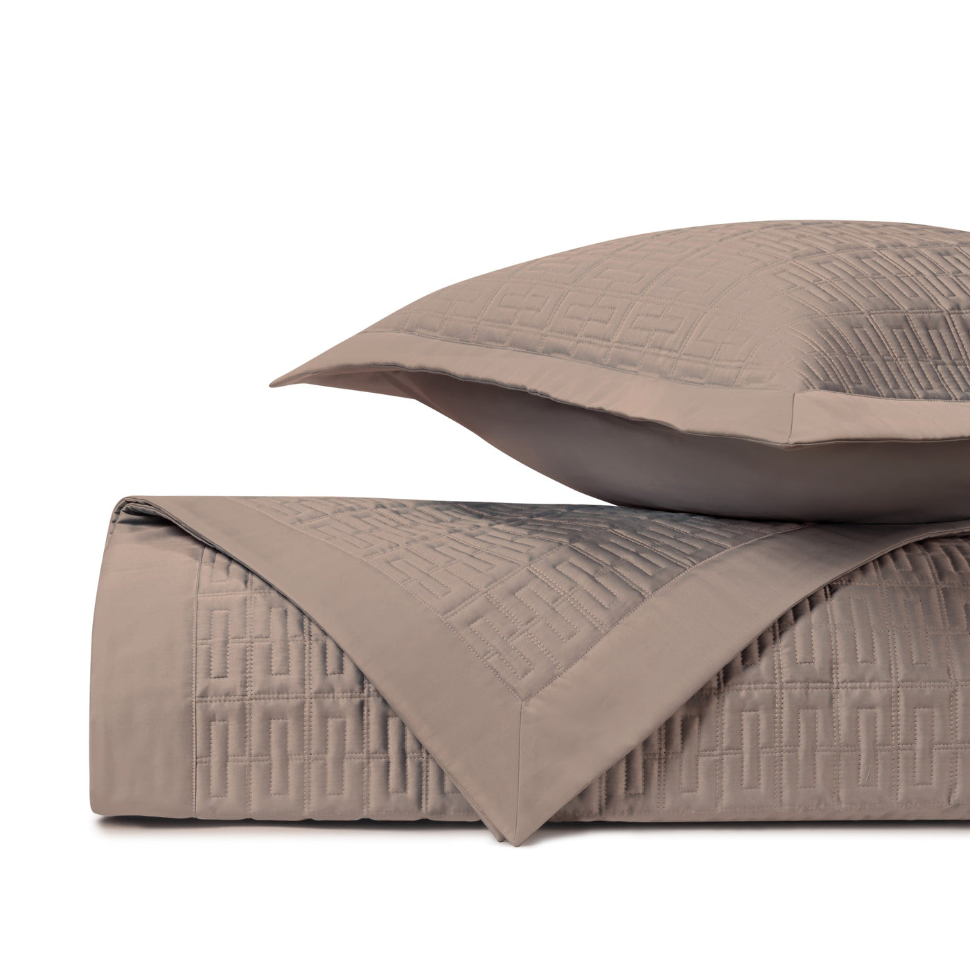 Close-up of taupe quilted coverlet with geometric Greek key stitching pattern and matching sham.