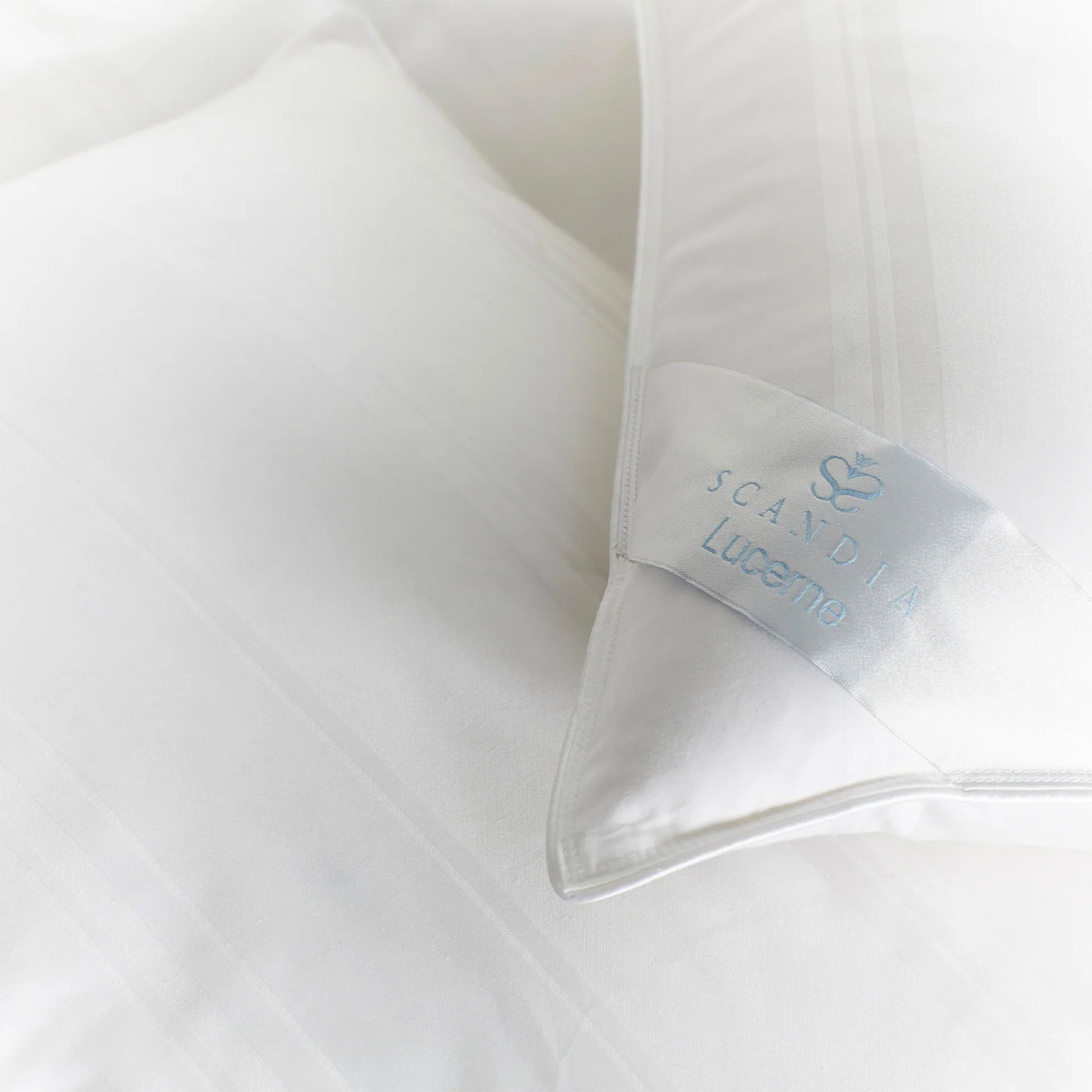 Close-up of Scandia Home Lucerne duvet label on ivory white down-fill bedding.