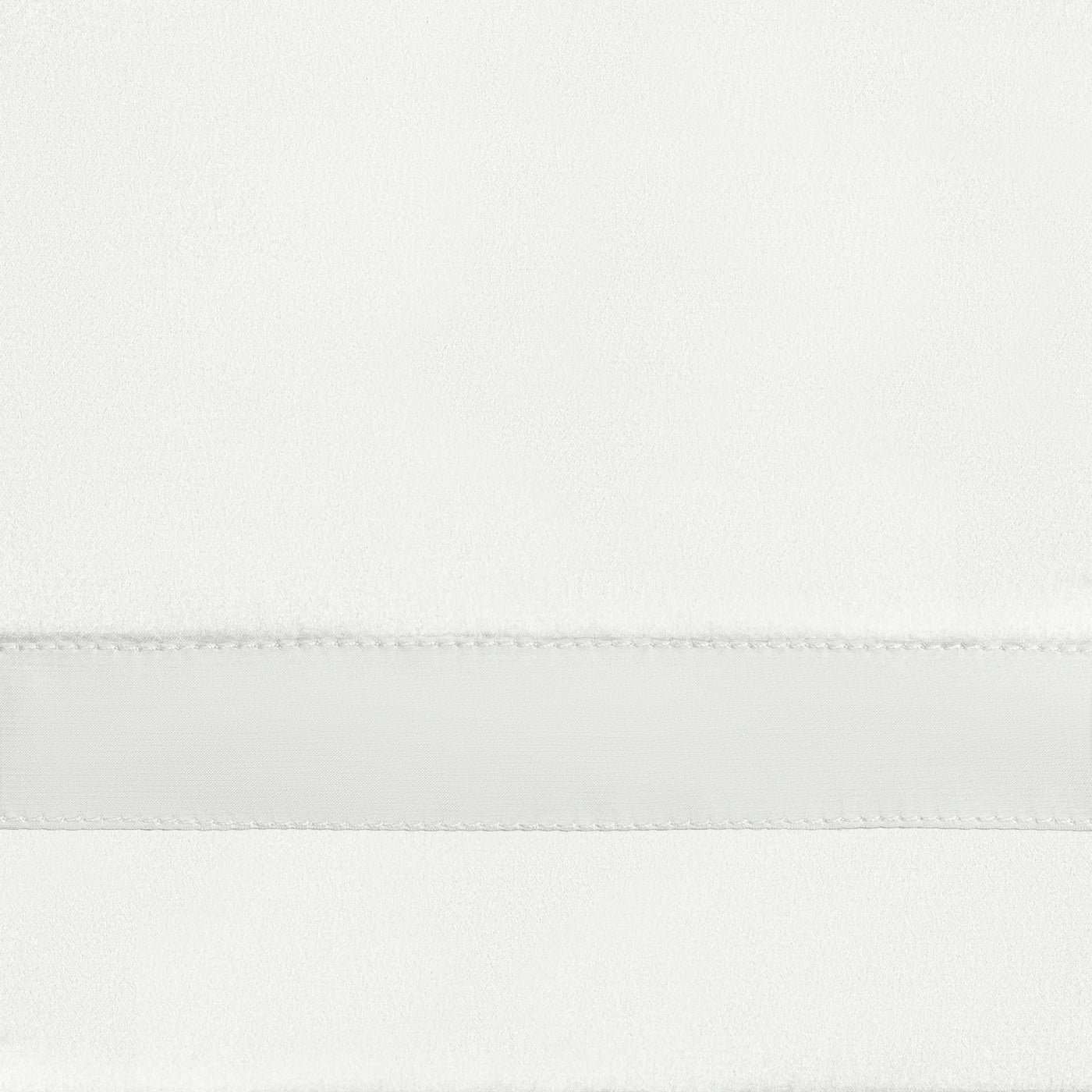 Close-up of white fitted sheet hem with satin border stripe detail.