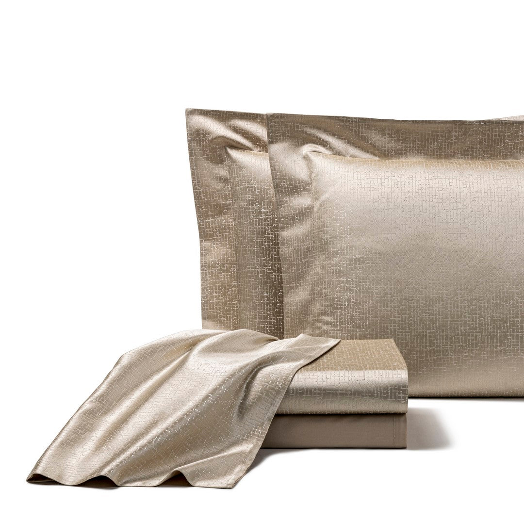 The Frette Luxe Glowing Weave Sham features a gold-colored, subtly textured cotton sateen design, neatly folded and displayed against a plain white background.