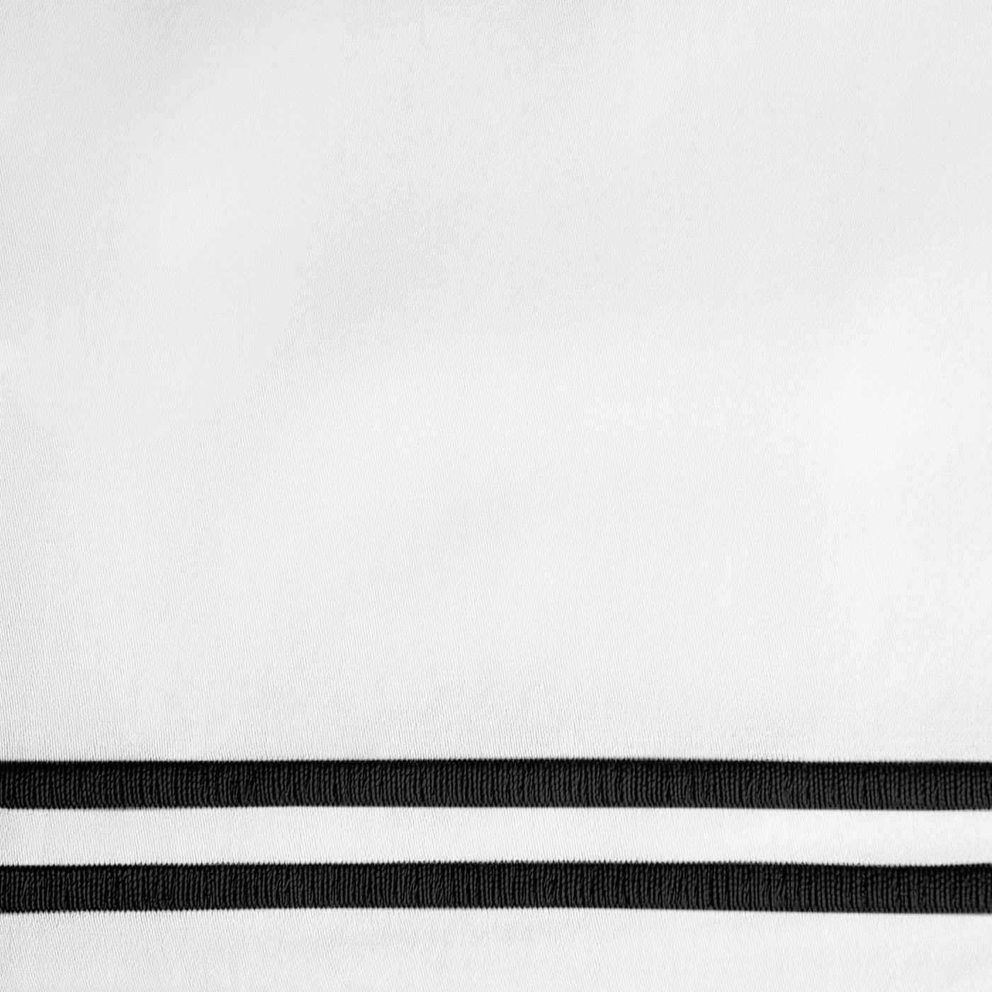 Close-up of white fabric with twin black embroidered border stripes.