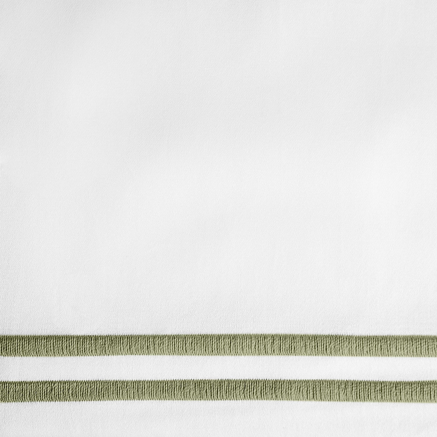 Close-up of sage green embroidered double-stripe border on white linen fabric.