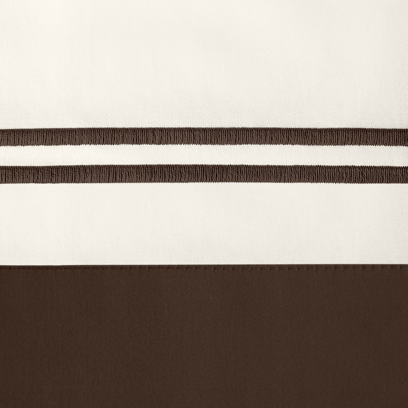 Close-up of ivory and chocolate cotton fabric with embroidered double-stripe border detail.